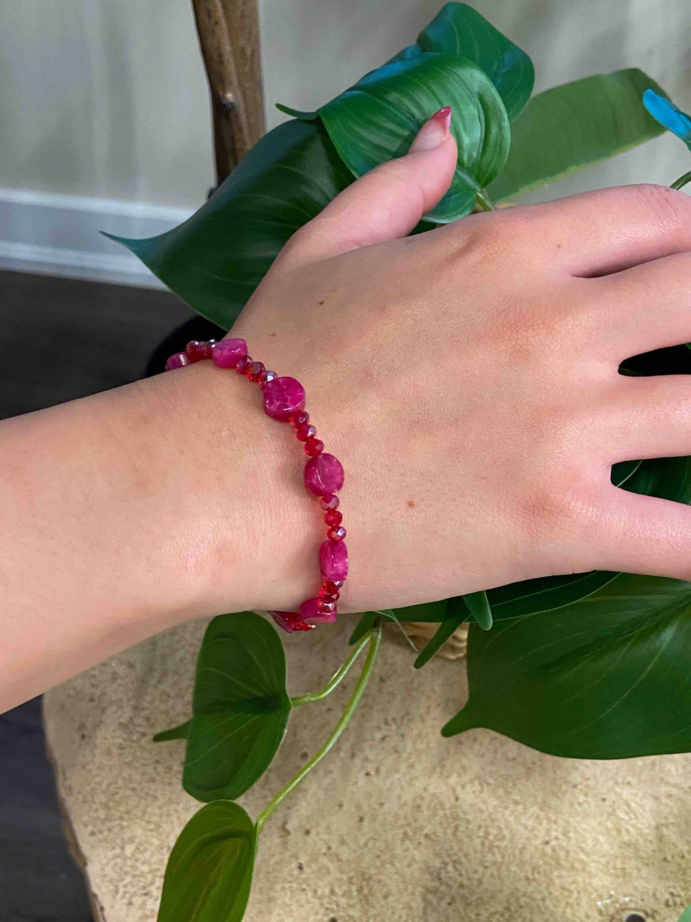 A handmade red crystal bead and pink rubellite stone bracelet.