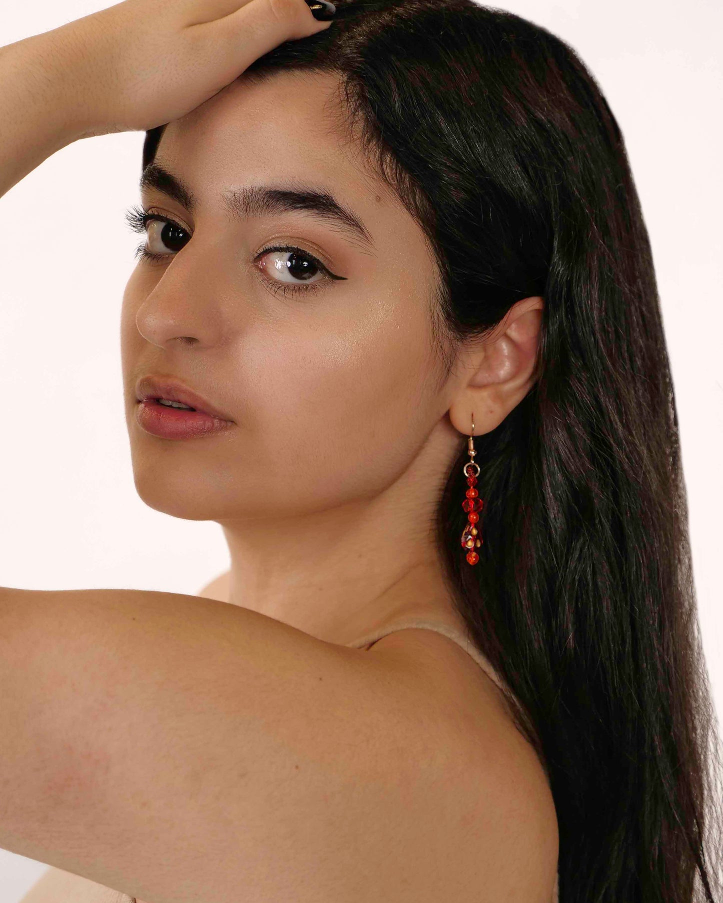 A handmade red and orange crystal beaded pair of dangle drop earrings with red glass charms.