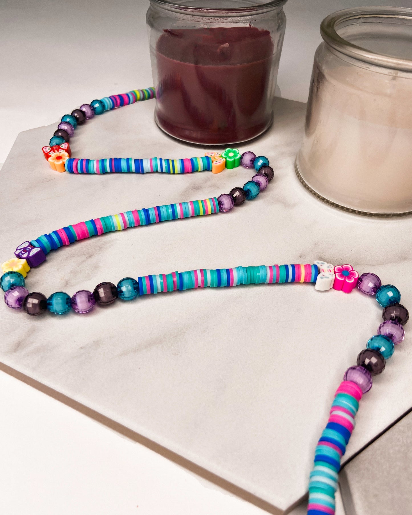 Handmade beaded belly chain made using multicolor flat rubber beads, flower and butterfly charms, and Discoball-like beads.