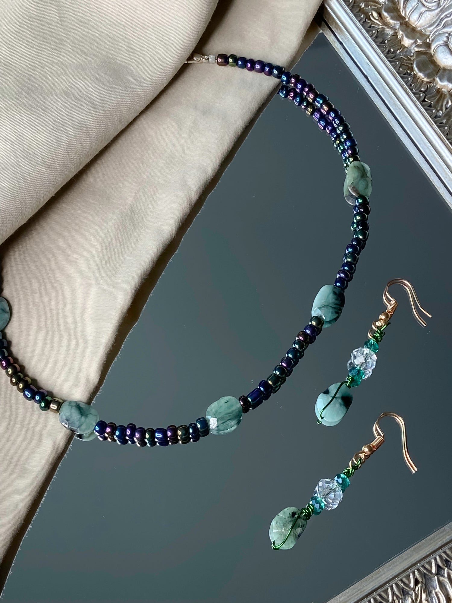 A matching emerald stone necklace and earrings set