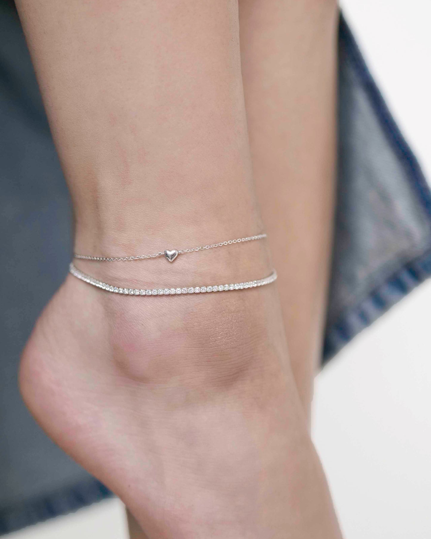 Sterling silver link chain anklet with a heart charm, and a Sterling silver zirconia stone tennis anklet.