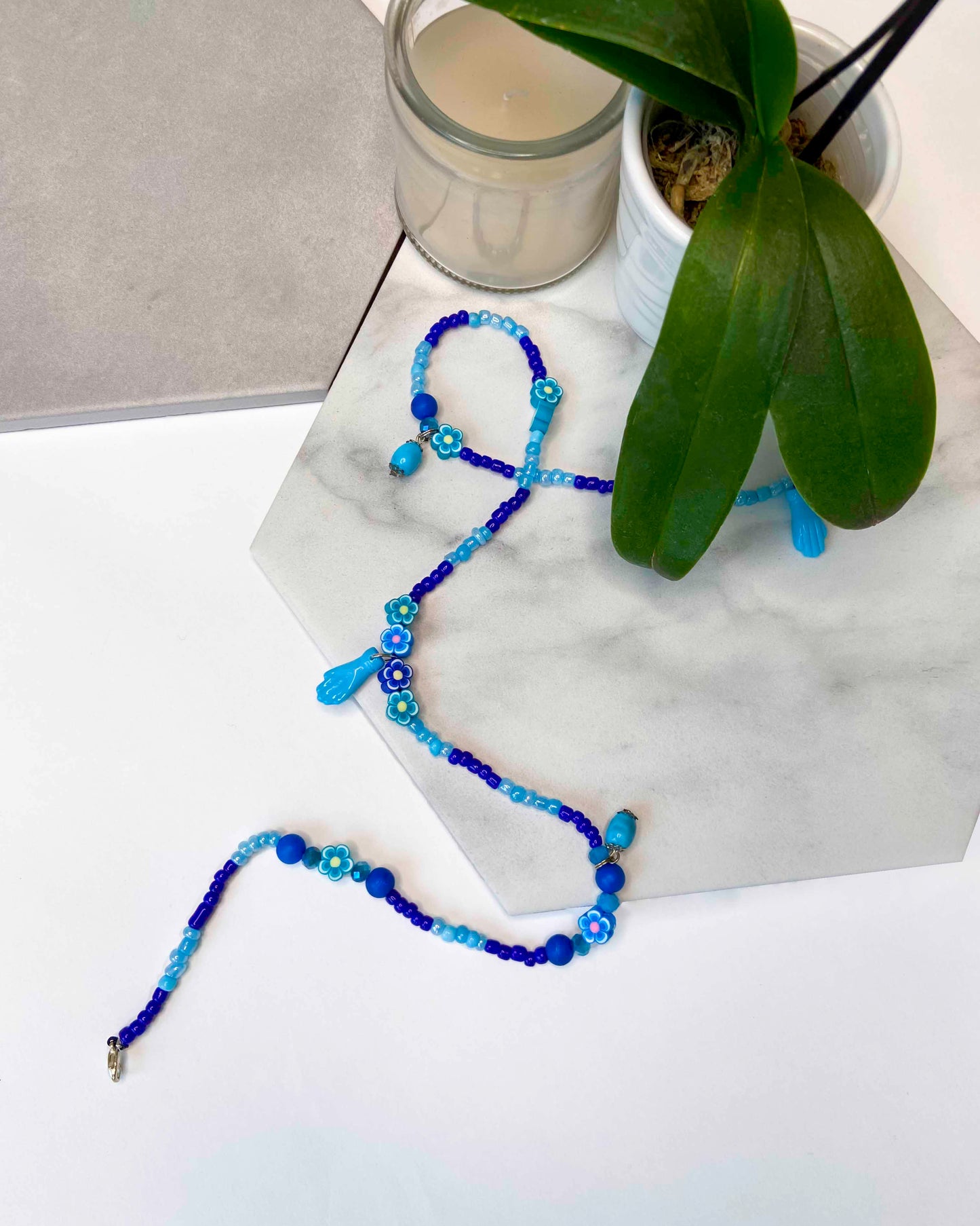 Handmade blue beaded belly chain made using light and dark blue beads, flower charms, turquoise stones, and hand charms.