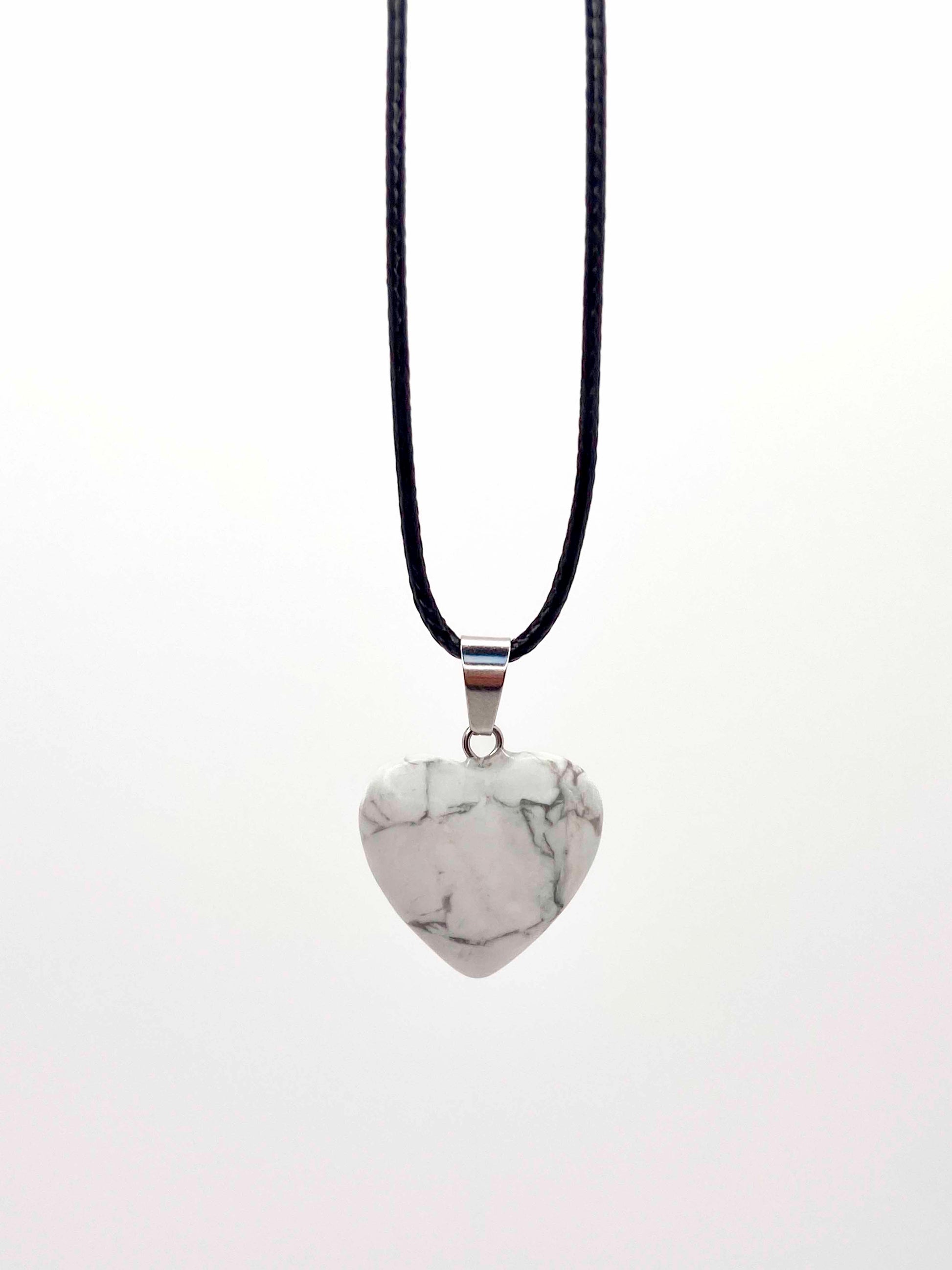 A handmade howlite heart pendant necklace with a black vegan leather string.