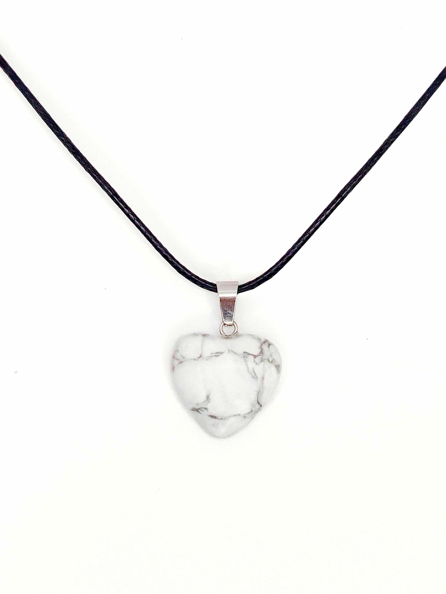 A handmade howlite heart pendant necklace with a black vegan leather string.