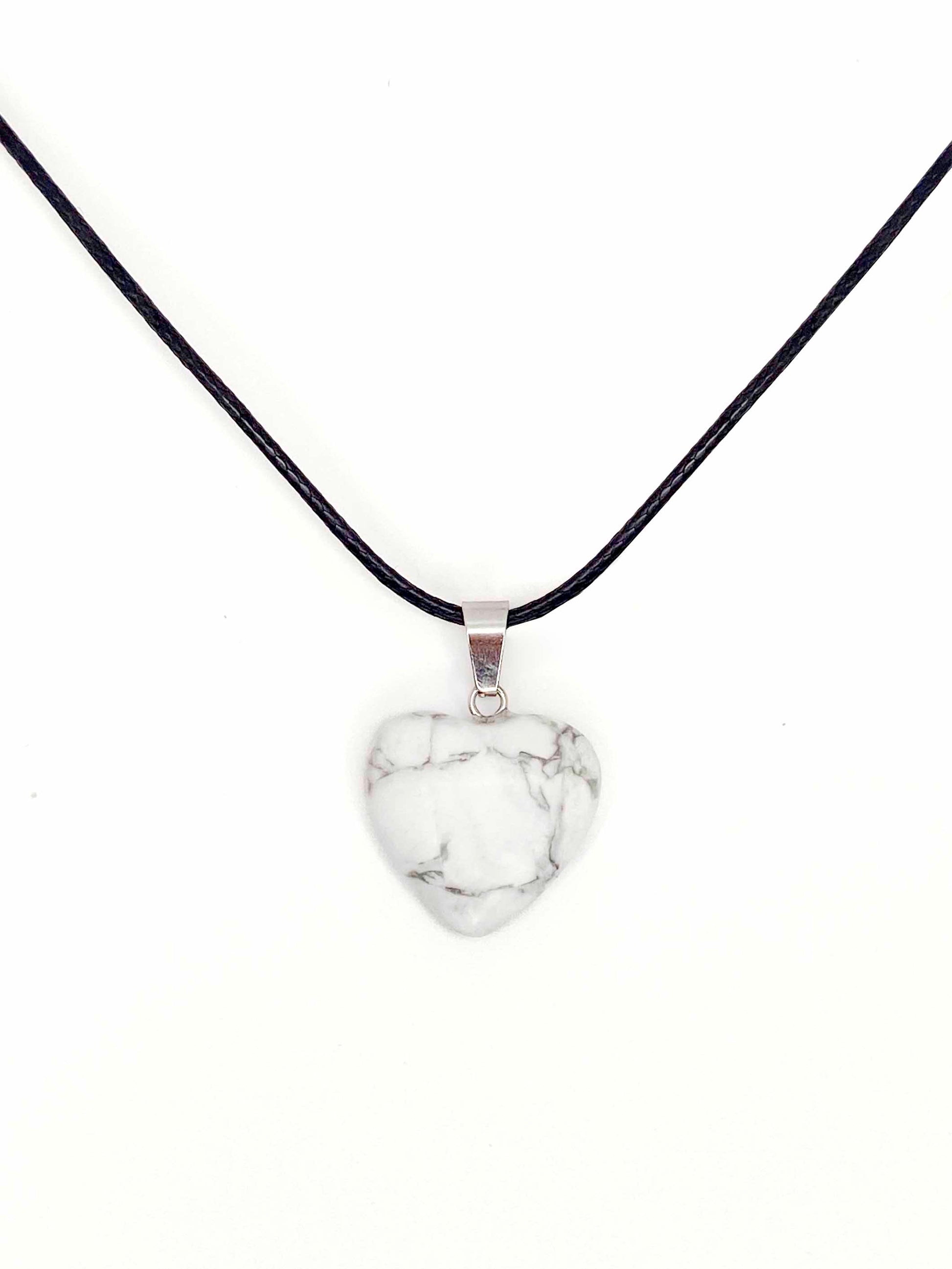 A handmade howlite heart pendant necklace with a black vegan leather string.