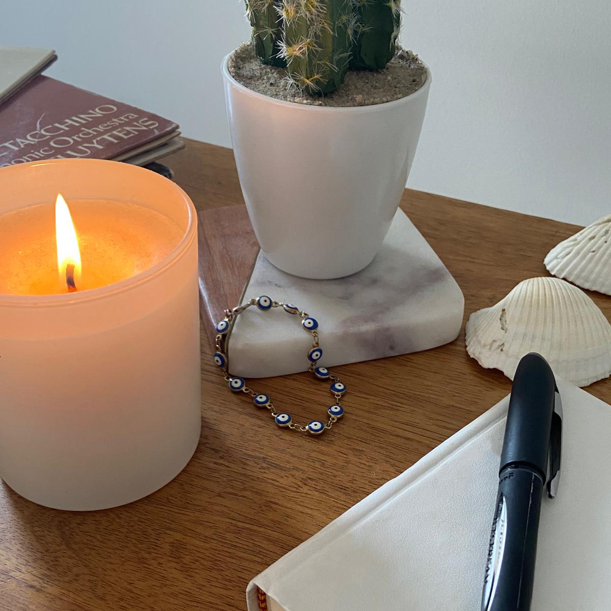 journaling with a navy blue evil eye chain bracelet.