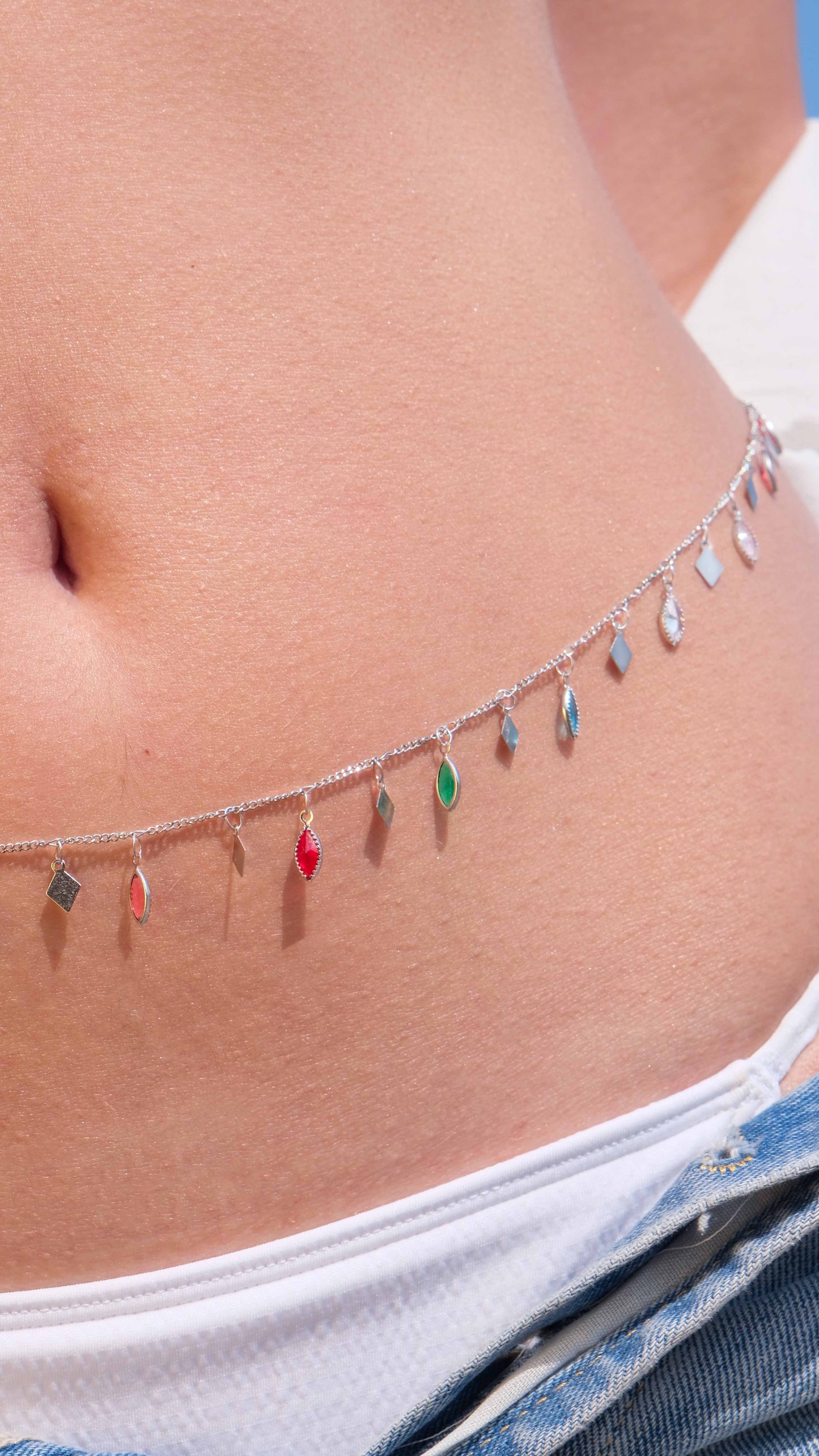 Silver waist chain with multicolor glass-like leaf charms, perfect for summer belly jewelry and silver plated body jewelry looks.