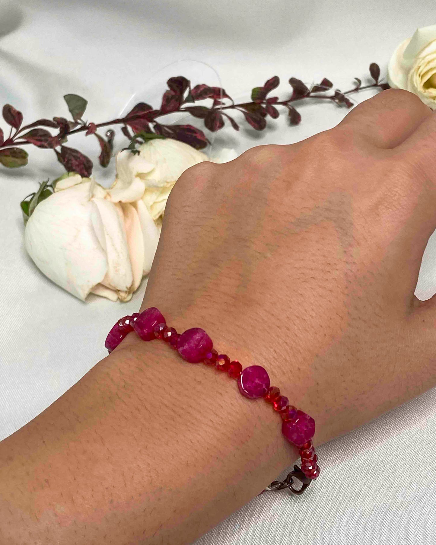 A handmade red crystal bead and pink rubellite stone bracelet.