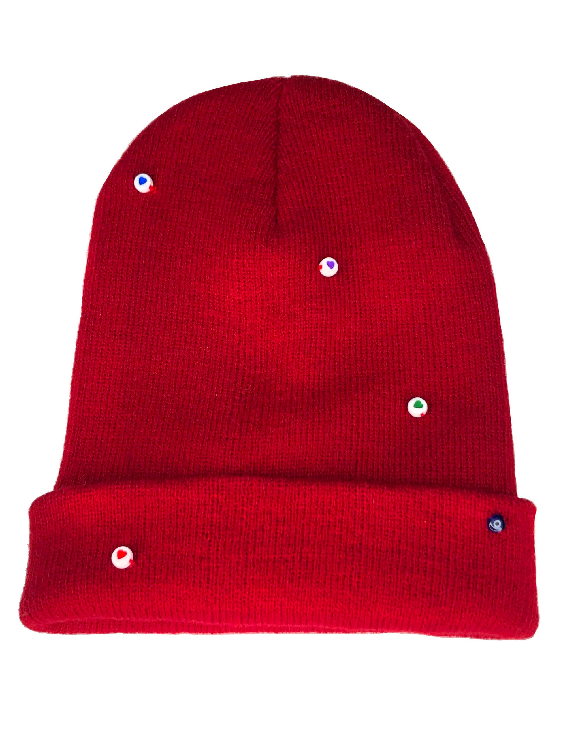 A red wool knit beanie decorated with both multicolor circle heart beads, and an evil eye charm.