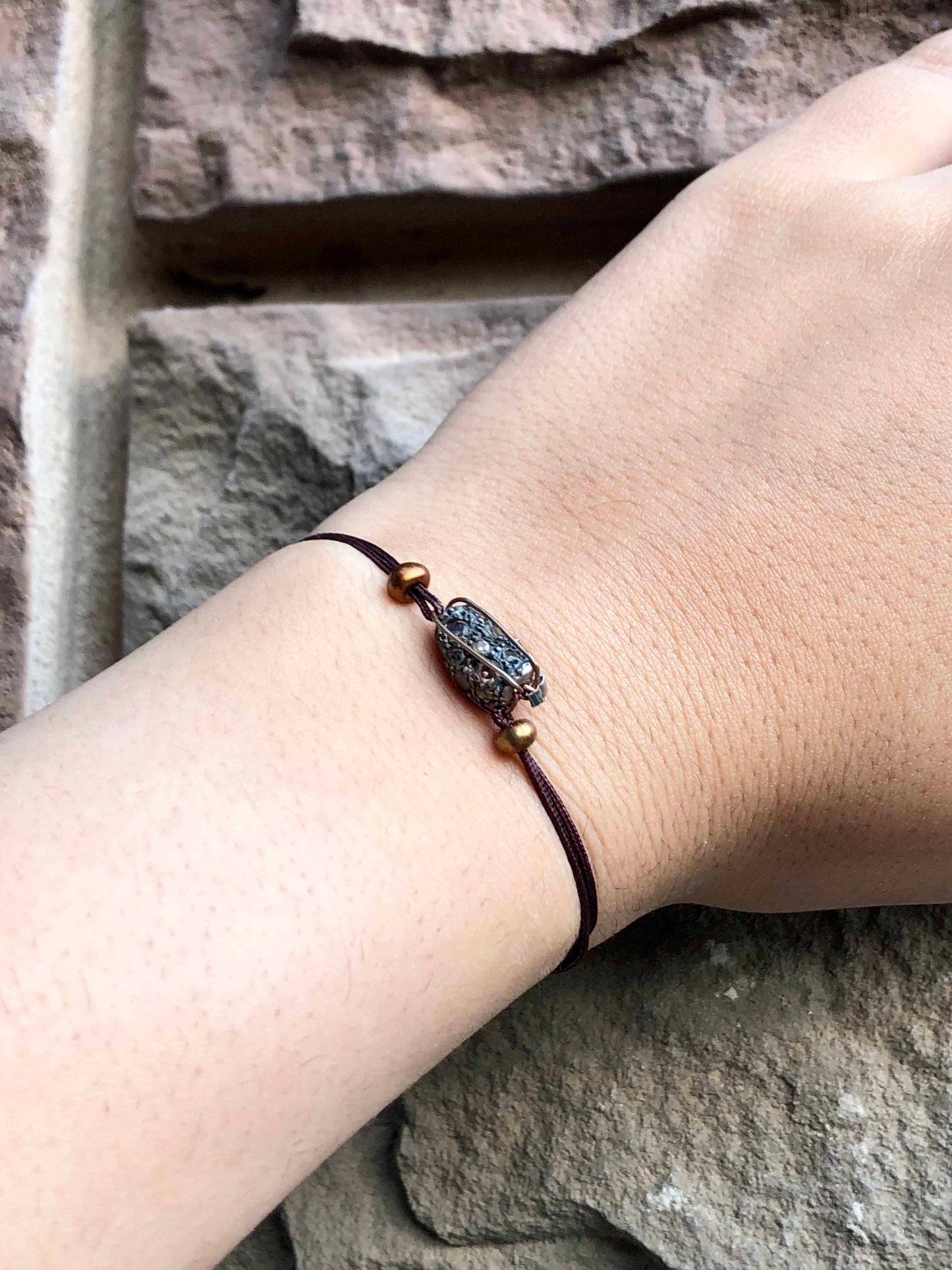 Handcrafted copper wire wrapped zirconium stone bracelet with two bronze beads.