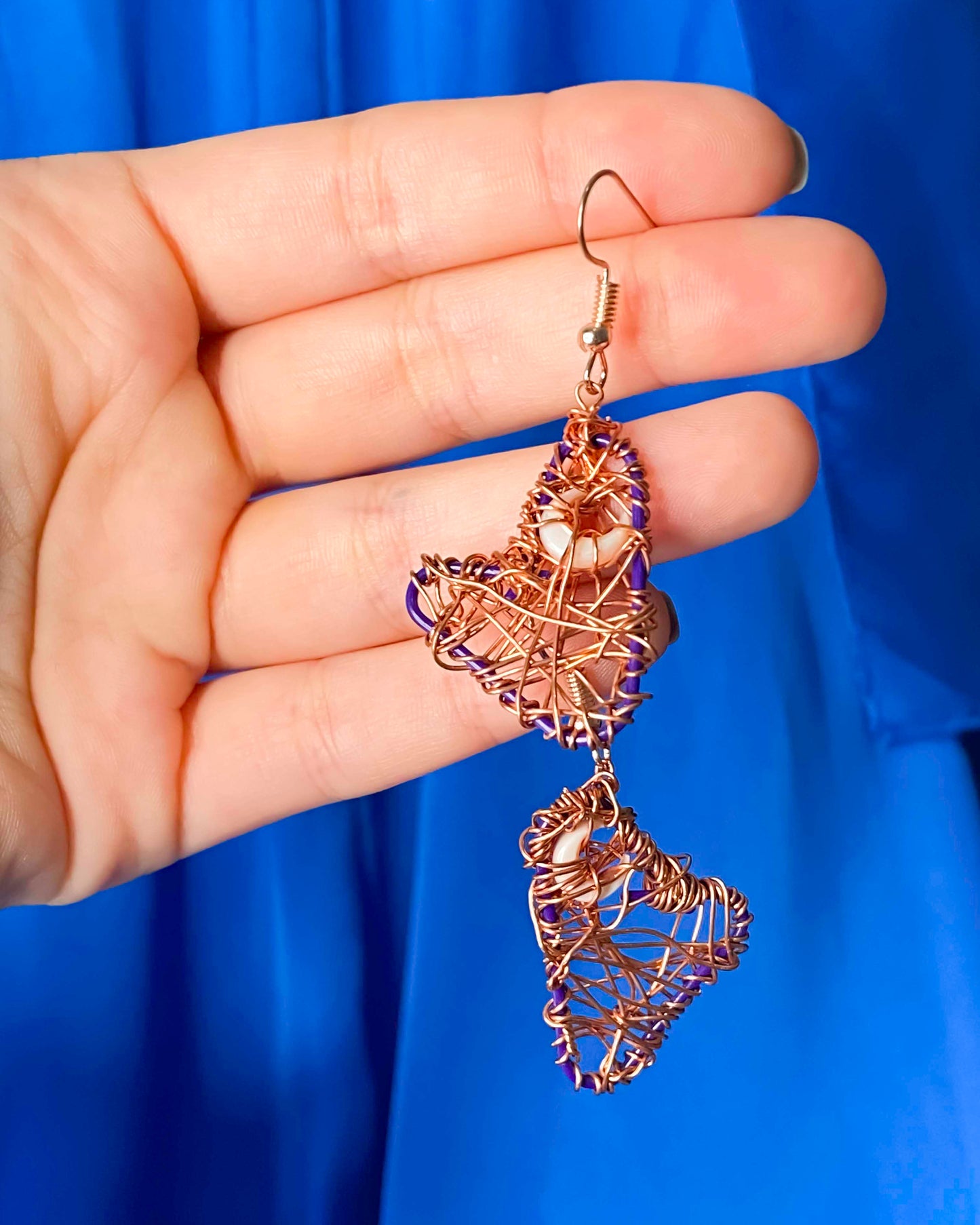 A pair of handmade copper wire wrapped crescent moon earrings.