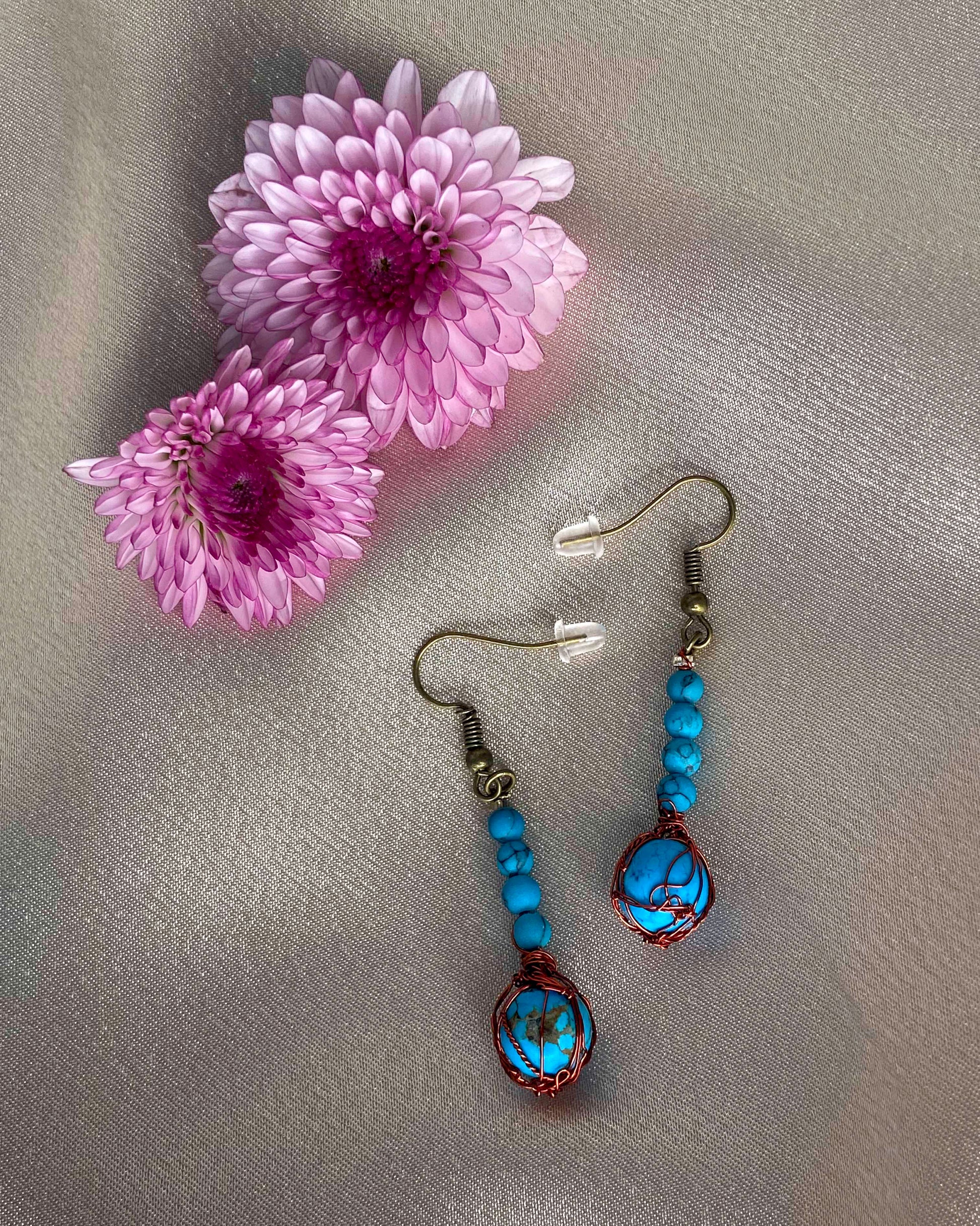 A pair of handcrafted wire-wrapped and beaded turquoise earrings.