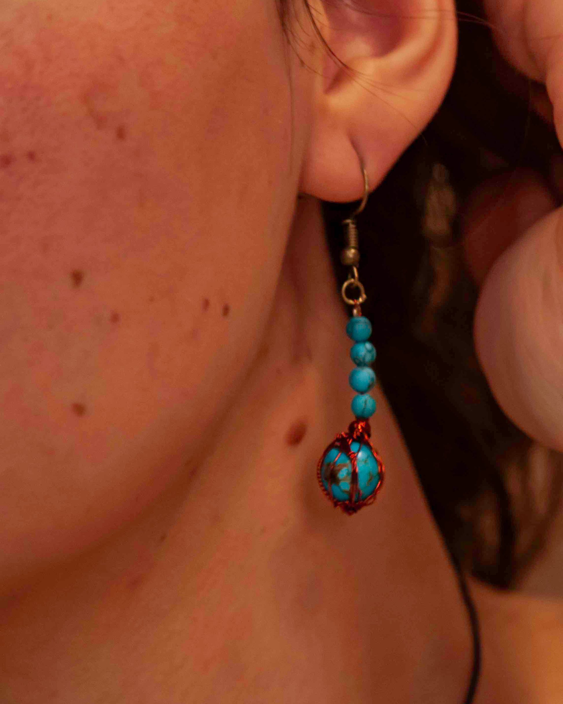 A pair of handcrafted wire-wrapped and beaded turquoise earrings.