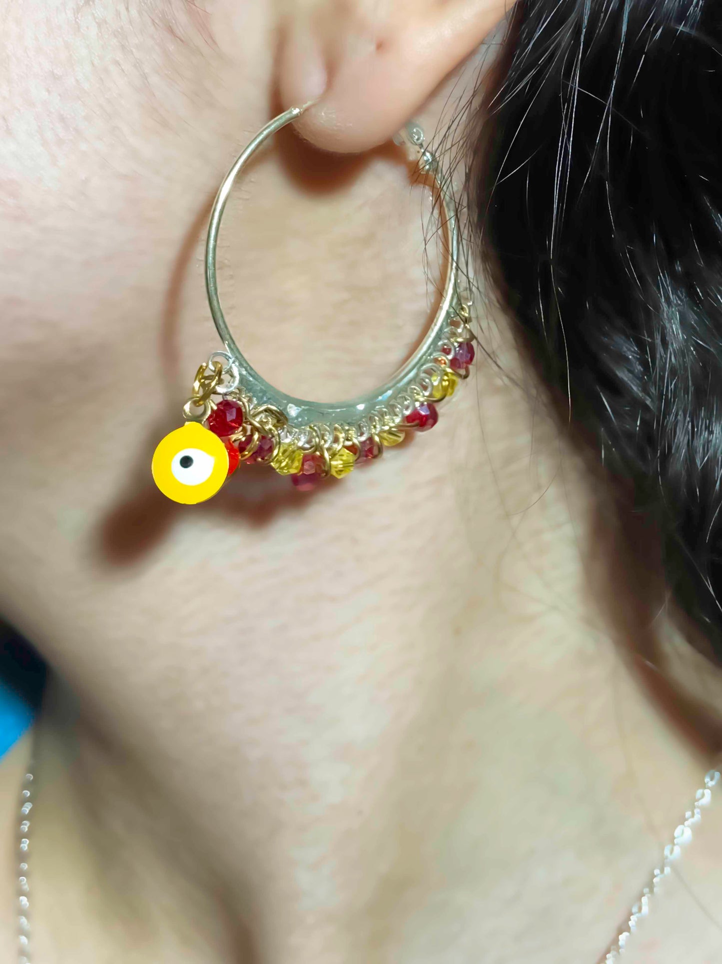 Handmade red and yellow evil eye charm and crystal beaded silver hoops.