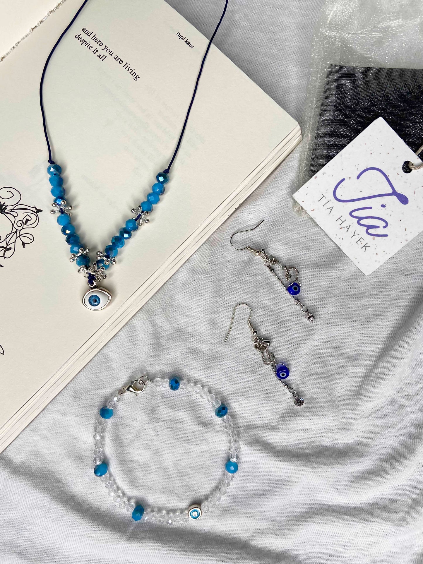 A matching handcrafted necklace, bracelet and earrings evil eye and crystal beaded set.