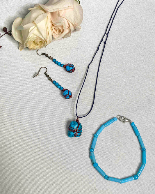A pair of handcrafted wire-wrapped and beaded turquoise earrings, a matching pendant necklace, and beaded bracelet.