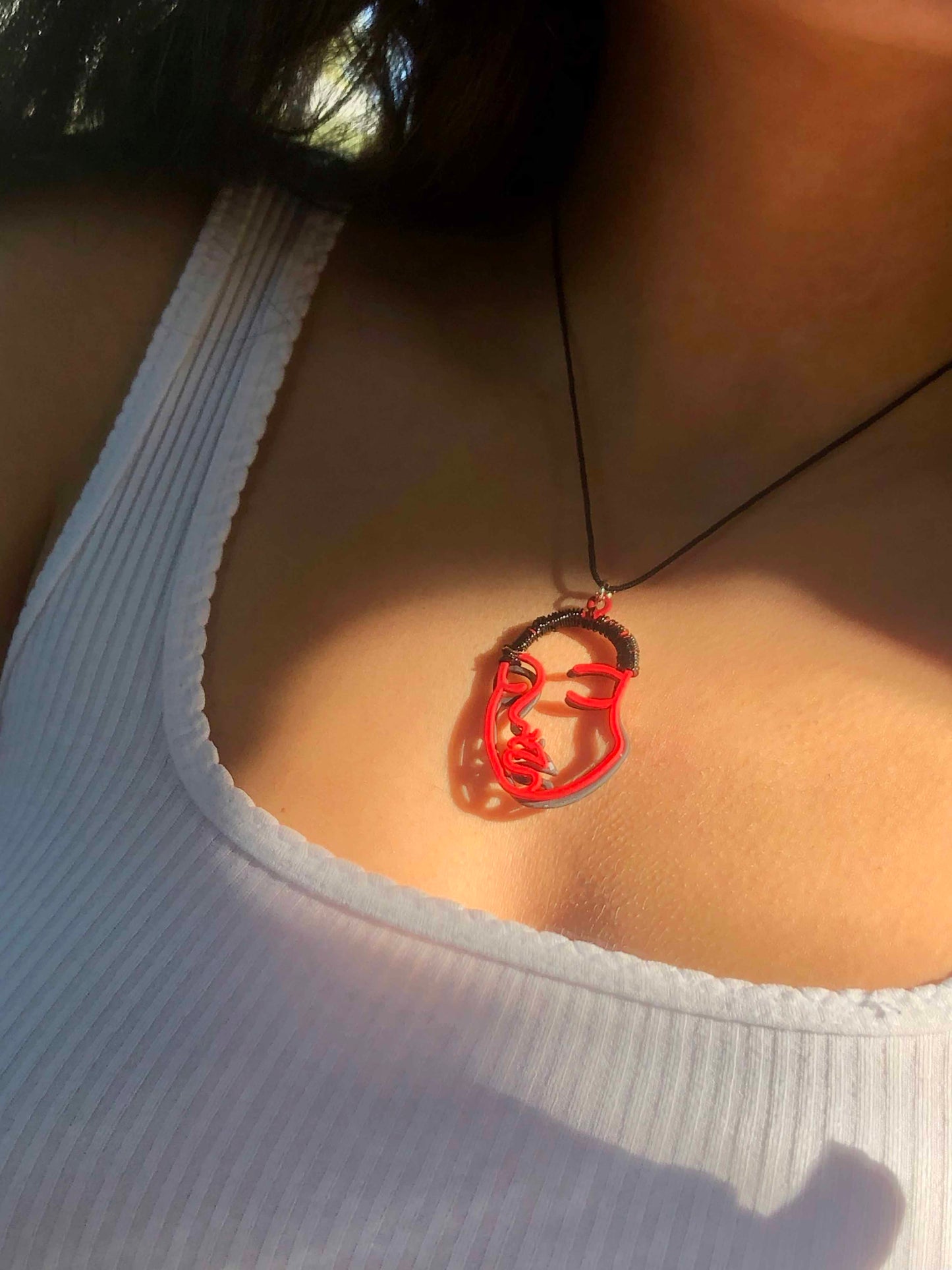 Handcrafted using hollowed-out black and red face charms wire wrapped together as one.