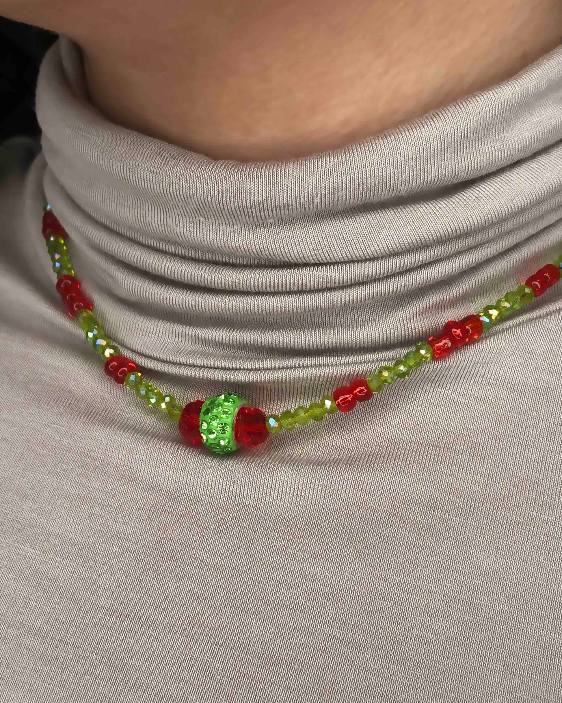 Handcrafted red and green crystal beaded necklace with rhinestone charm at its center.