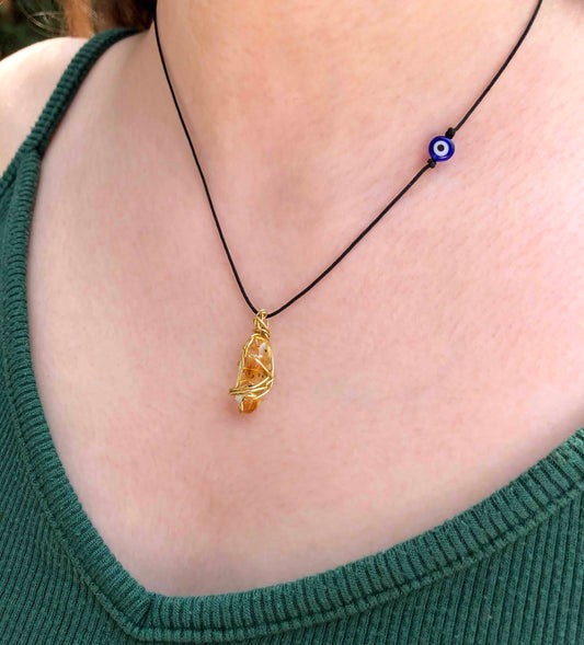 yellow tourmaline golden wire wrapped necklace with evil eye charm.