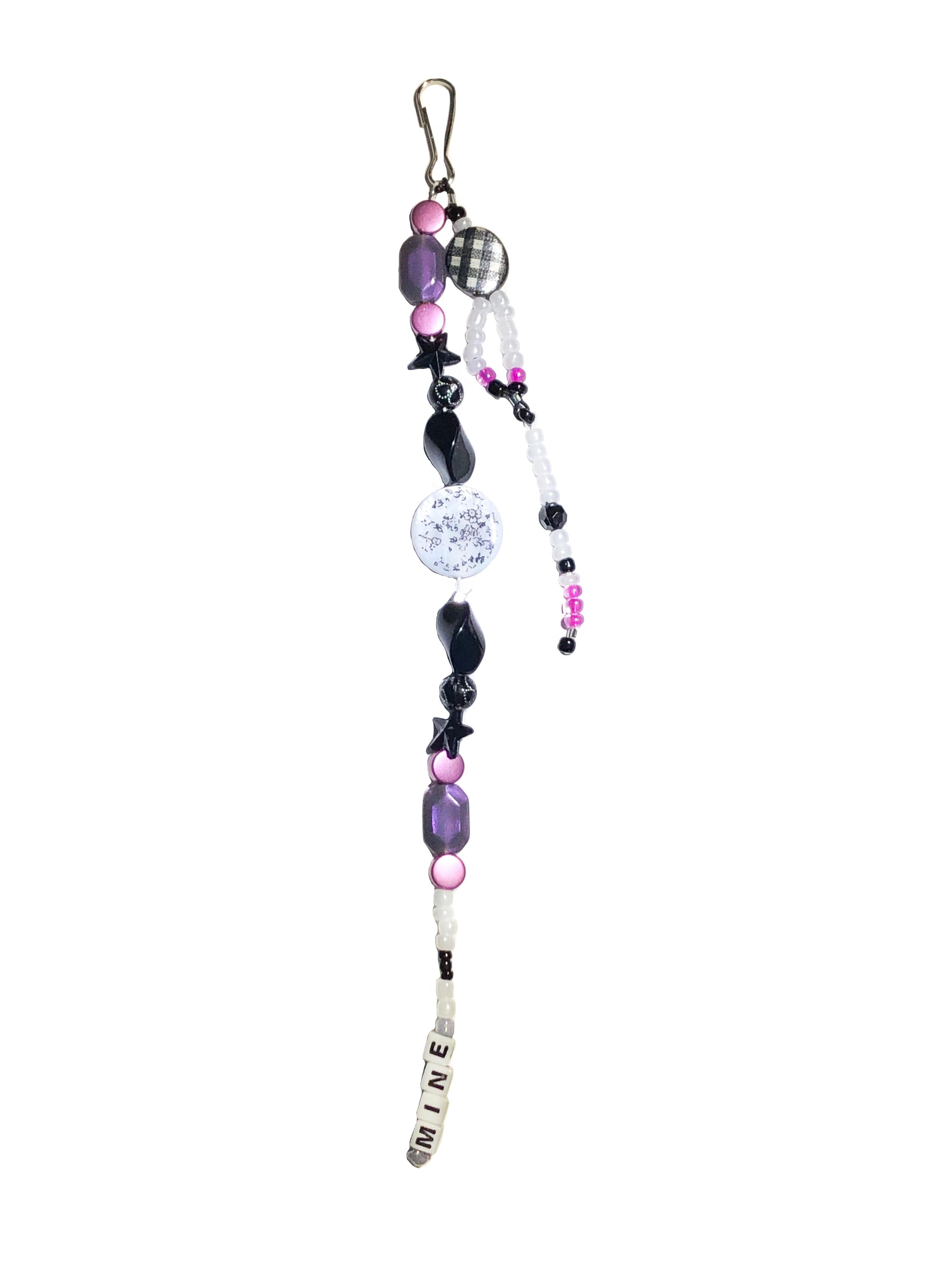 White, black, purple and pink beaded bag charm. Handcrafted with black stars, a coin floral print charm, and mine beaded using letter beads.