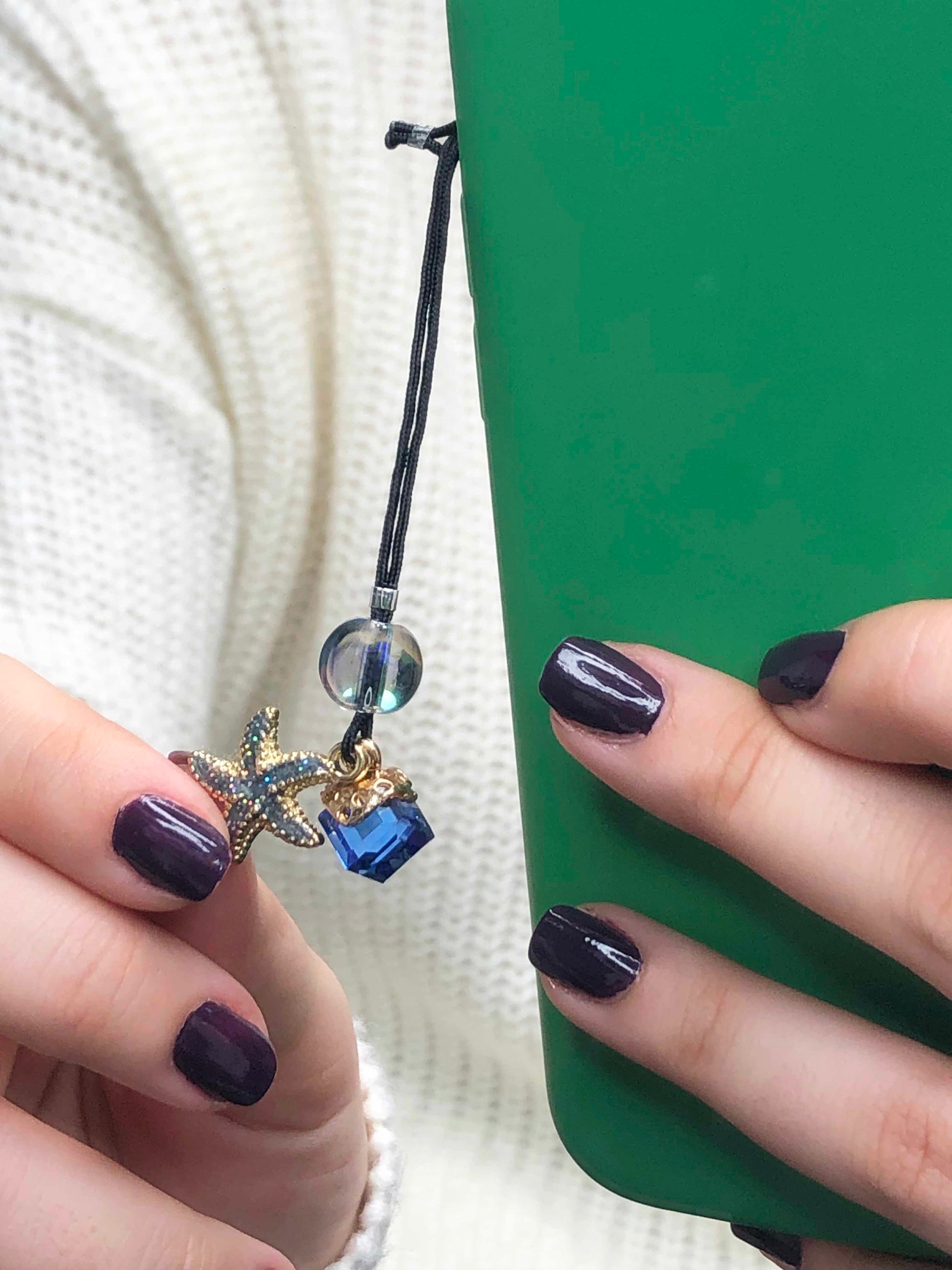 Handmade beaded phone charm made using starfish charm, a glass bead, and a blue glass cube charm.