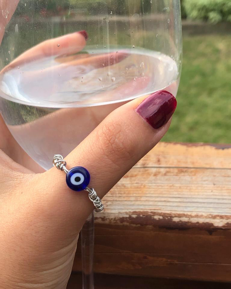Handmade silver wire wrapped blue evil eye charm ring.