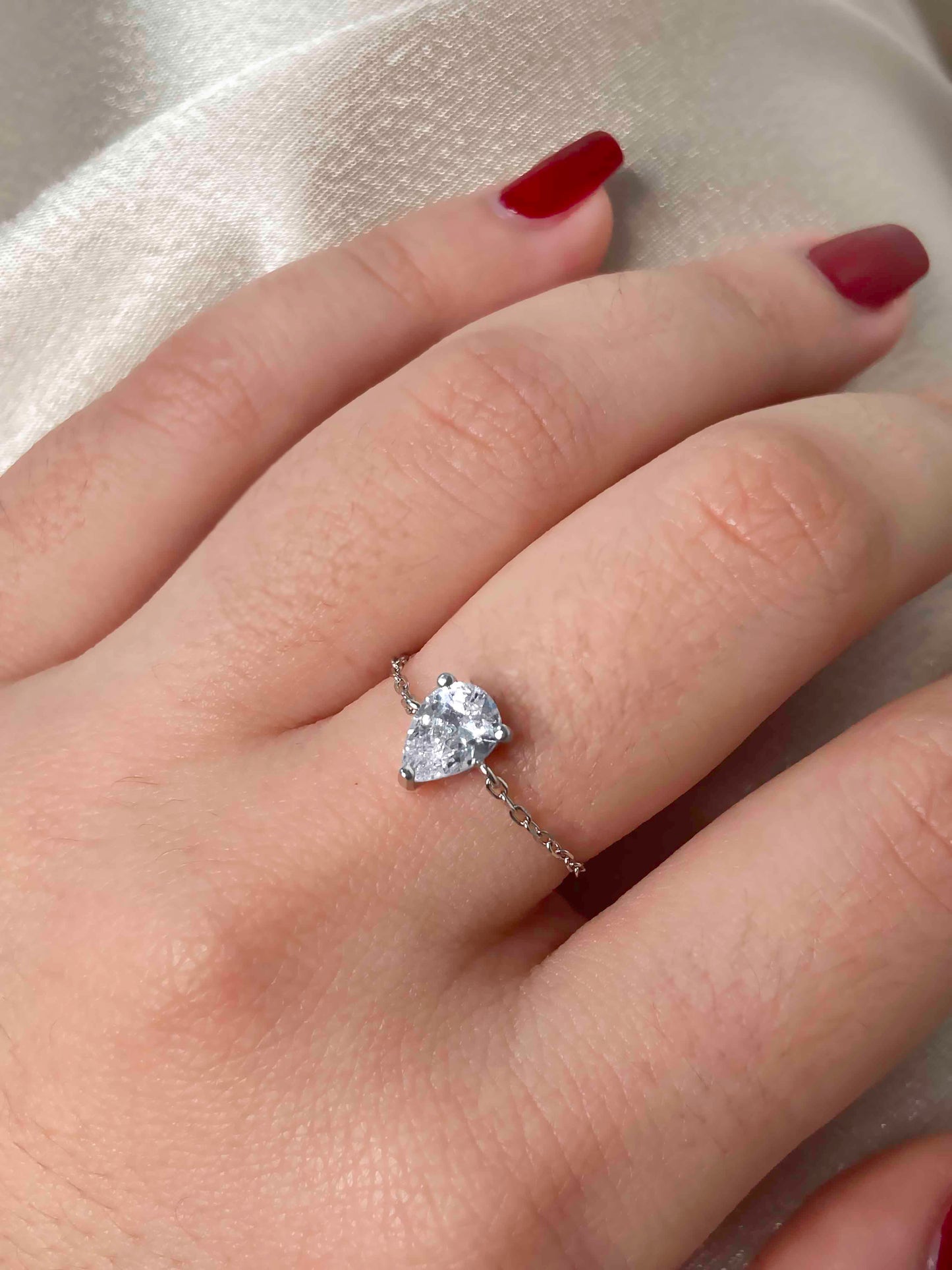 Handcrafted adjustable 925 sterling silver pear-shaped cubic zirconia ring.