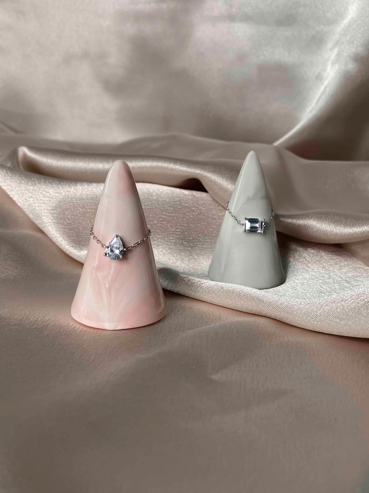 Handcrafted adjustable 925 sterling silver rectangle and pear-shaped cubic zirconia rings.
