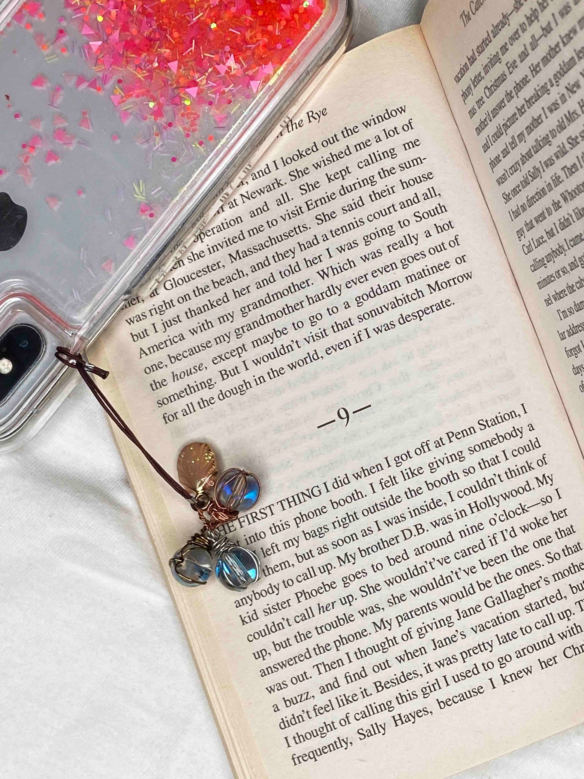 handmade phone charm with three wire wrapped glass beads and a sea shell charm.