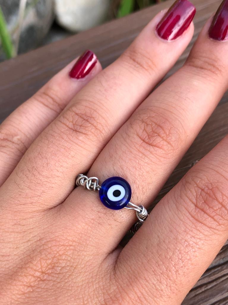 Handmade silver wire wrapped blue evil eye charm ring.