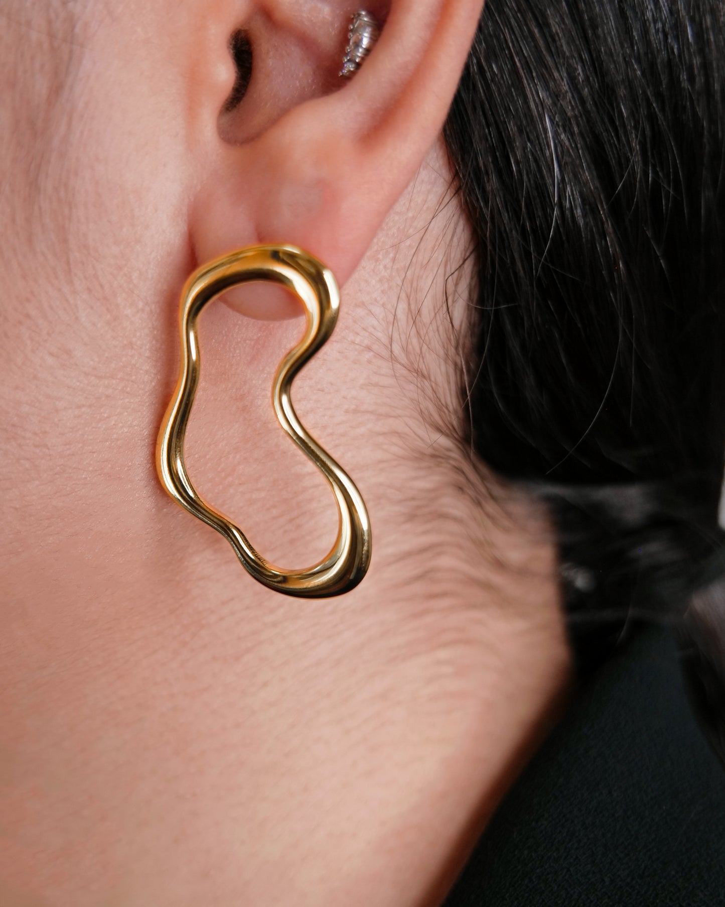 irregular hollow earrings, asymmetrical abstract earrings styled for evening wear, gold and silver finish
