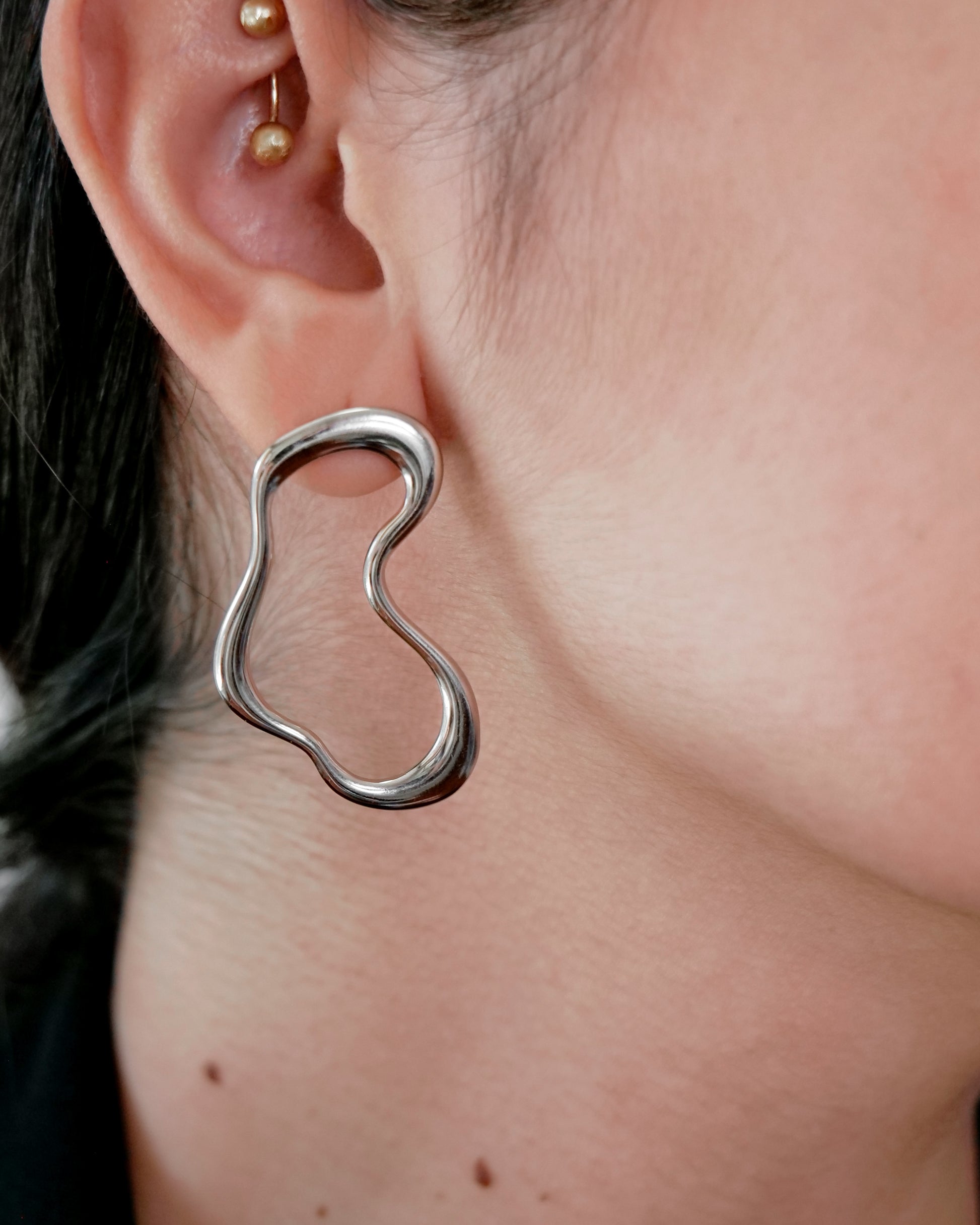 irregular hollow earrings, asymmetrical abstract earrings styled for evening wear, gold and silver finish
