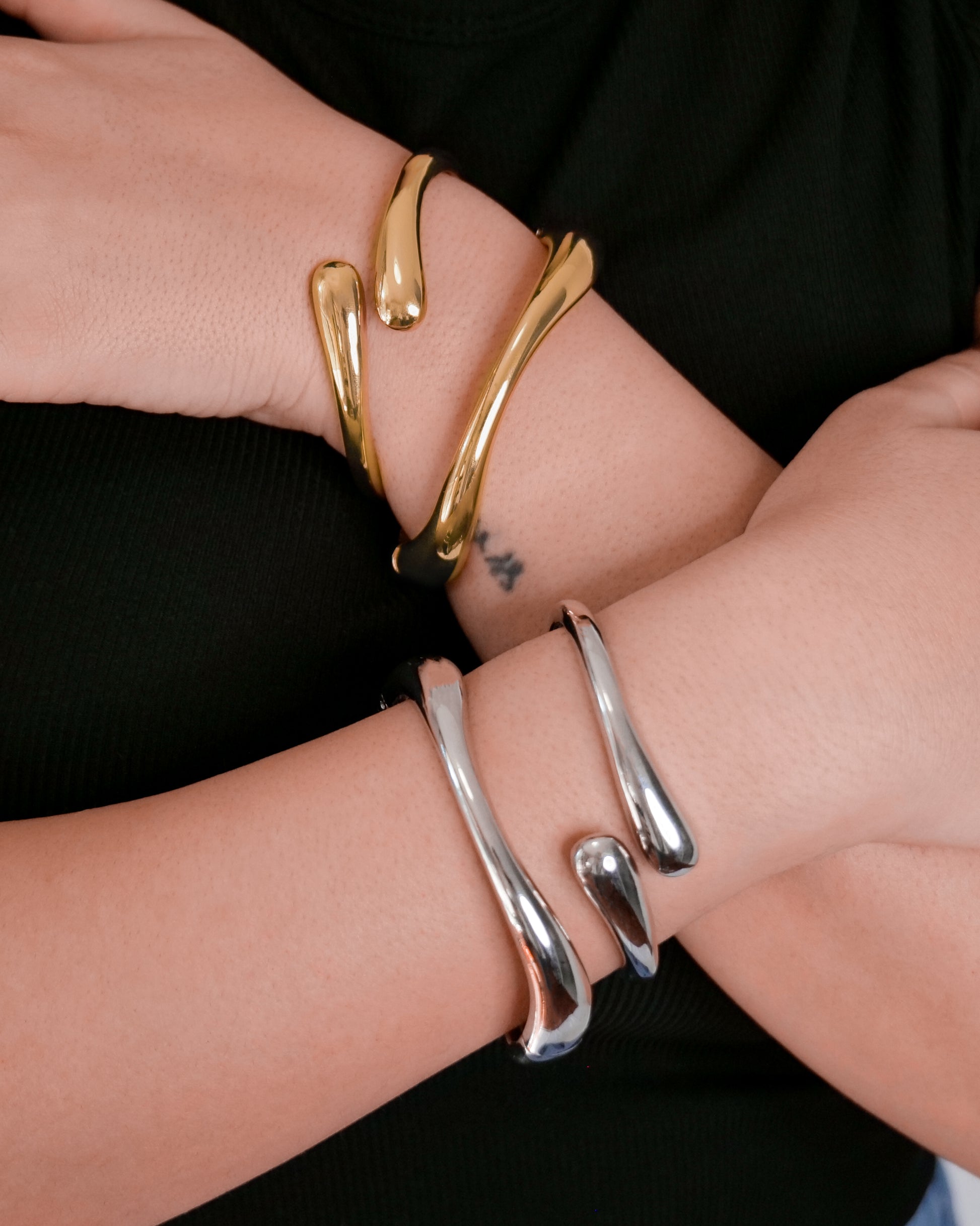 Gold and silver cuff bangle stacked with slim open bangle, modern abstract jewelry.