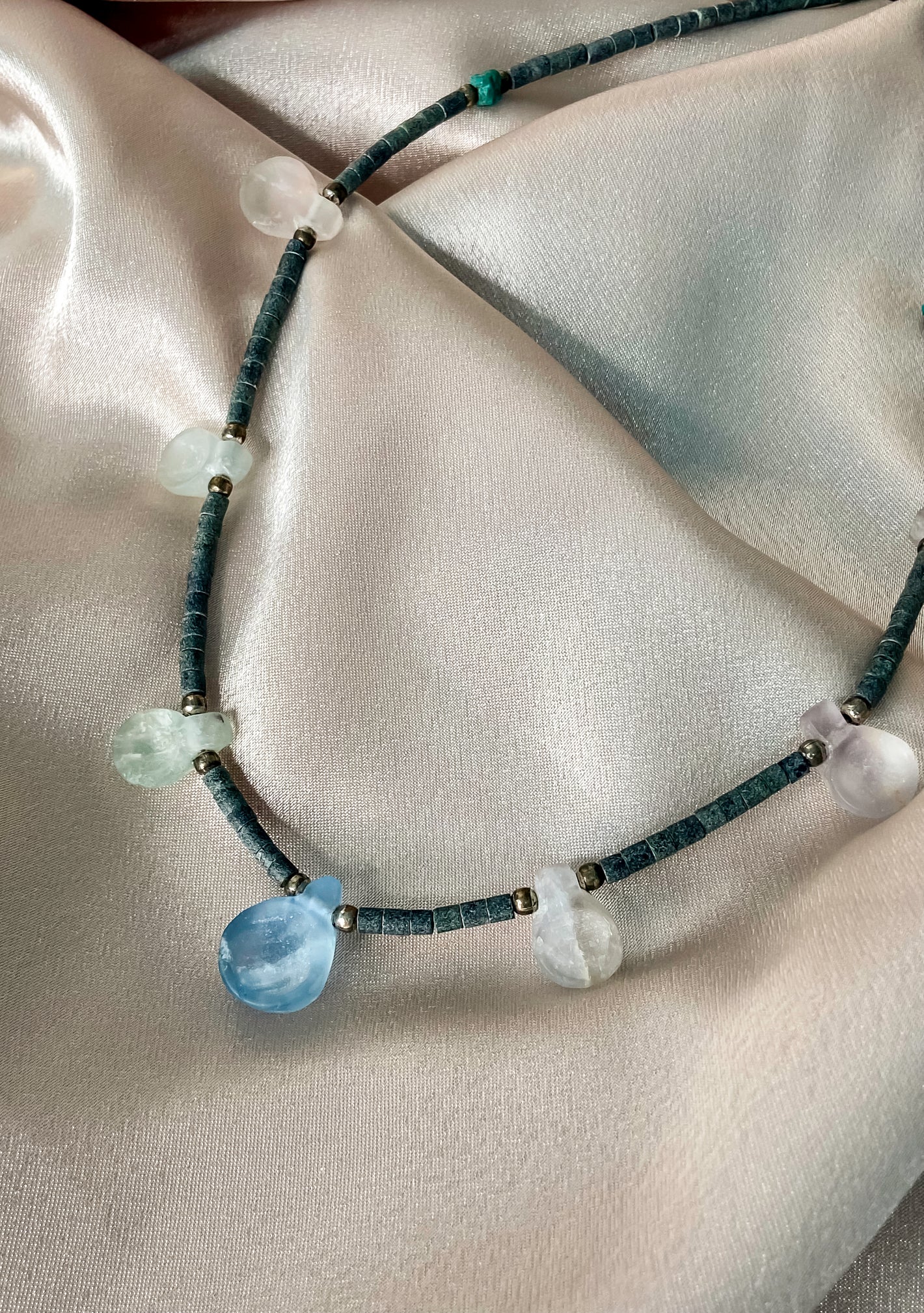 Handcrafted beaded necklace made using carved crystal quartz, turquoise, silver balls, and granite cylinder beads