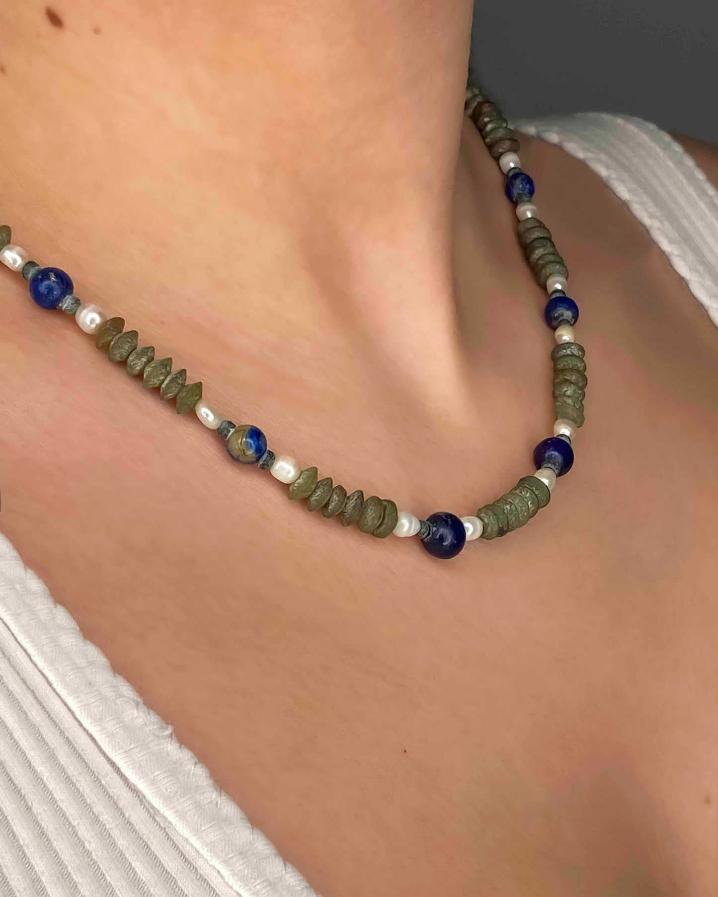 close up of semi-precious gemstone necklace made using lapis lazuli, pearls and serpentine.