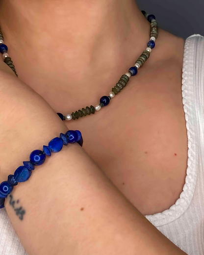 close up of semi-precious gemstone necklace and bracelet made using lapis lazuli, pearls and serpentine.