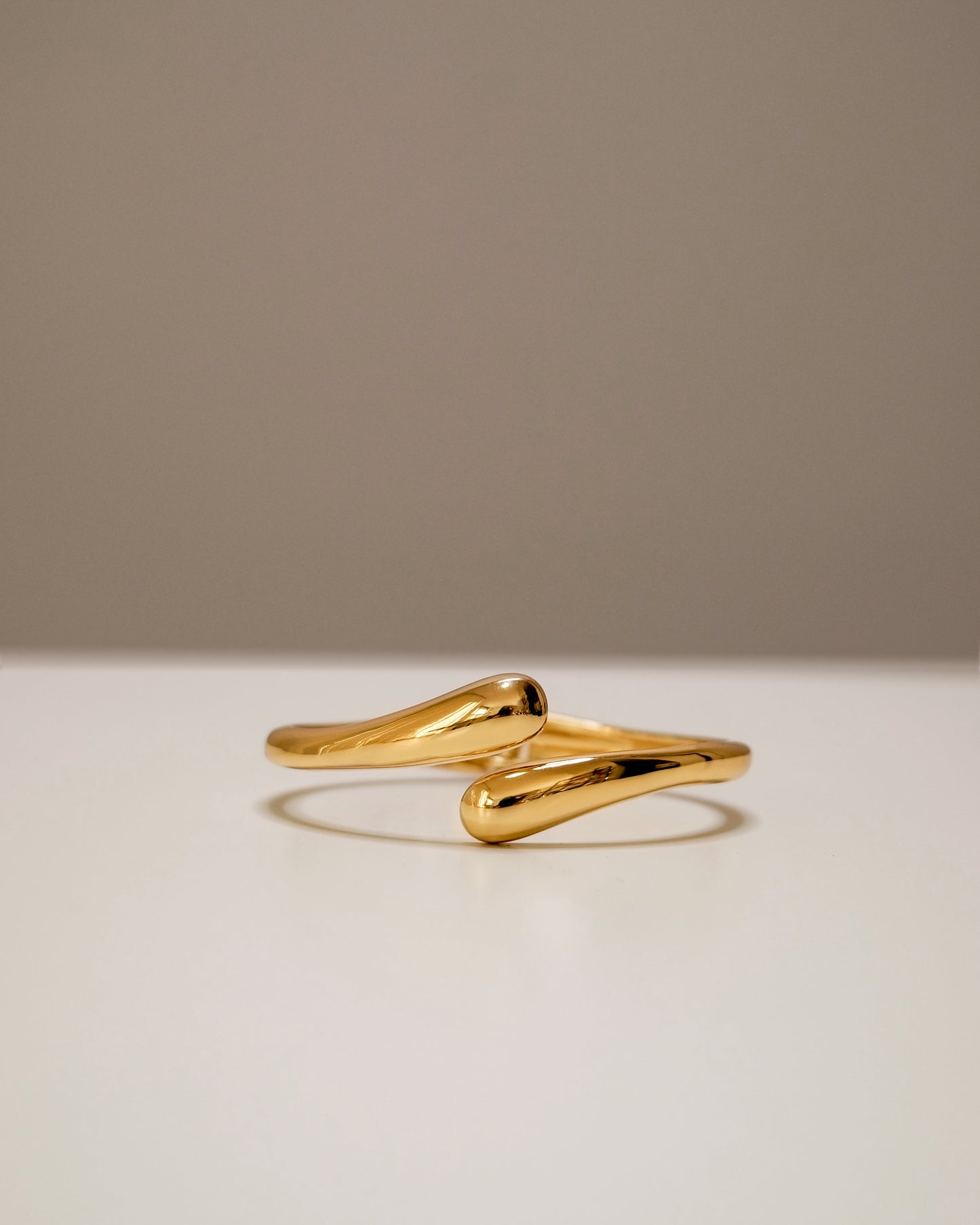 Open gold bangle, a modern balance of bold and minimal design.