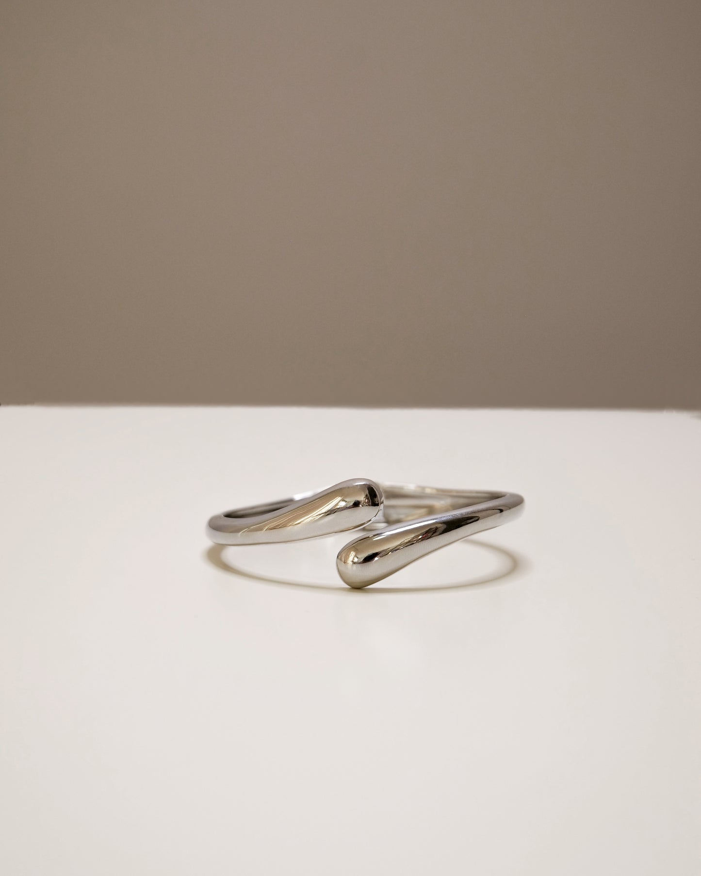 Open silver bangle, a modern balance of bold and minimal design.