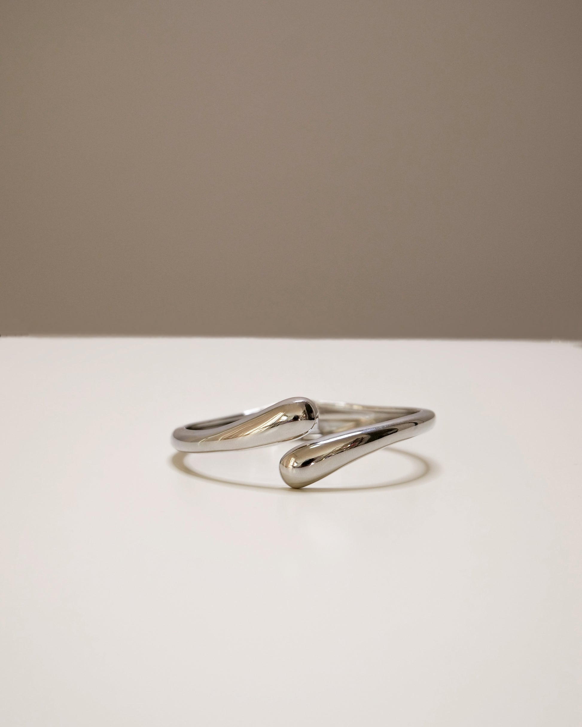 Open silver bangle, a modern balance of bold and minimal design.