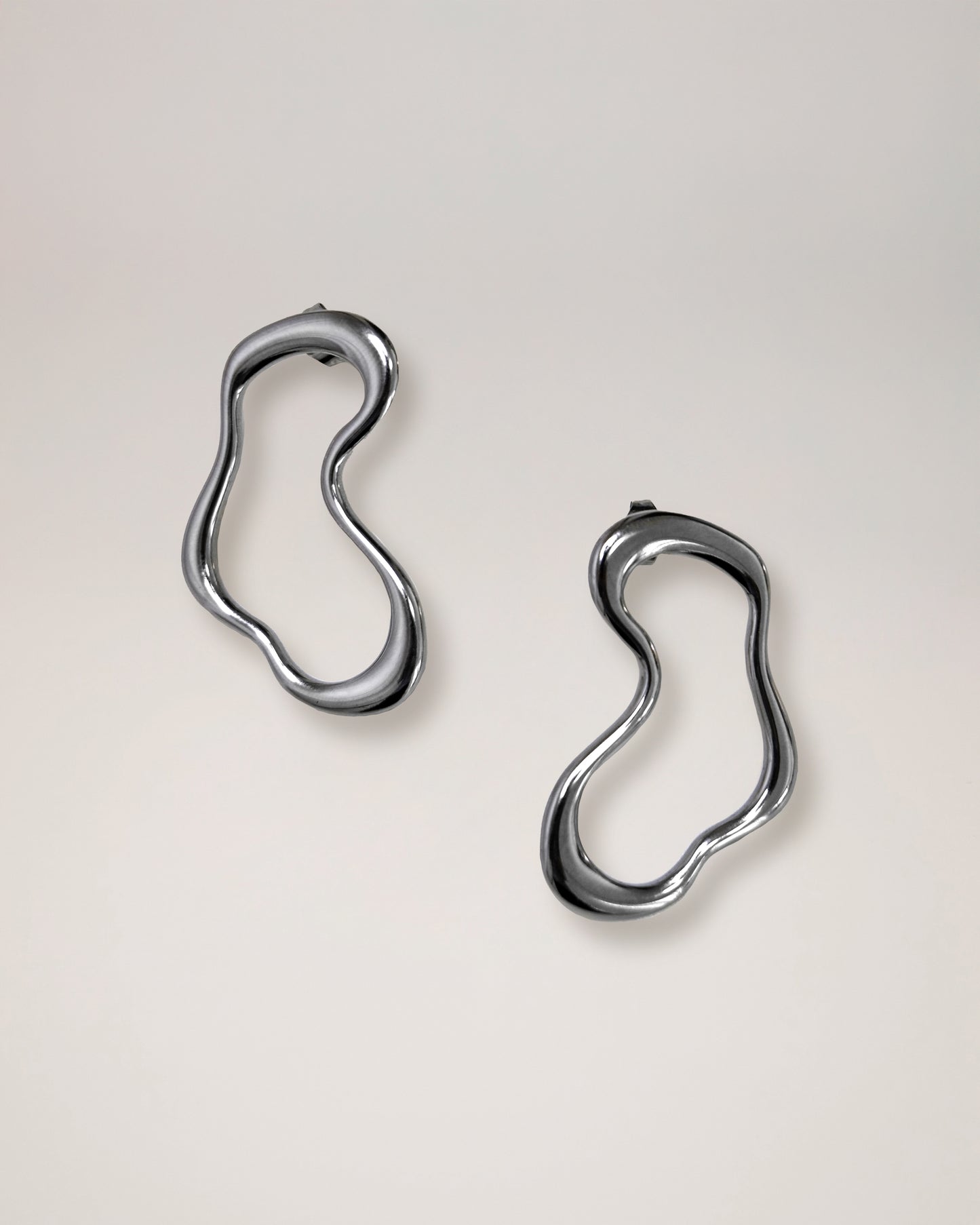 irregular hollow earrings, asymmetrical abstract earrings styled for evening wear, gold and silver finish
