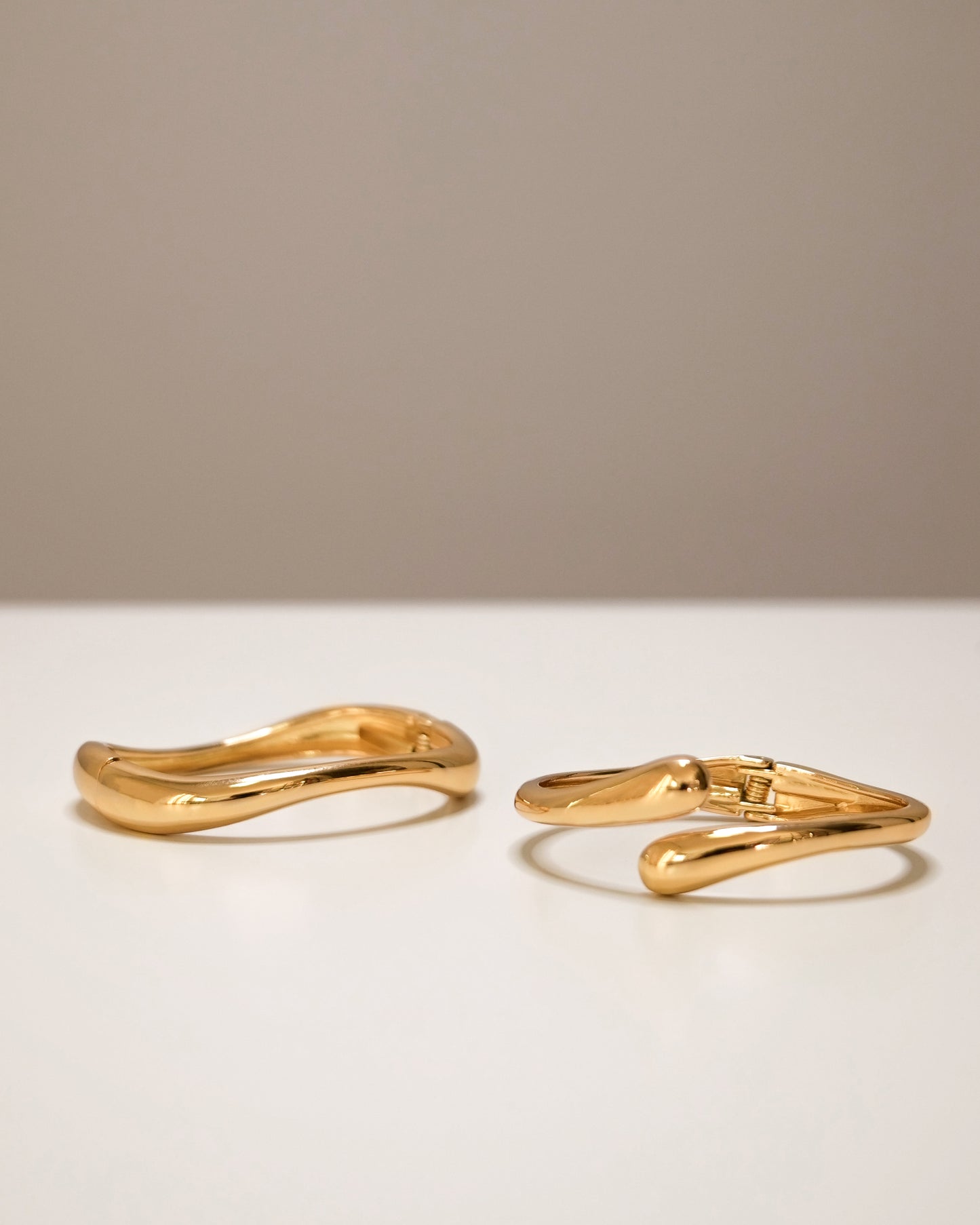 Gold cuff bangle stacked with slim open bangle, modern abstract jewelry