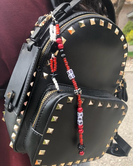 Handmade beaded bag charm with letter beads that spell out yes and no.
