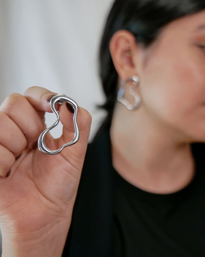 irregular hollow earrings, asymmetrical abstract earrings styled for evening wear, gold and silver finish