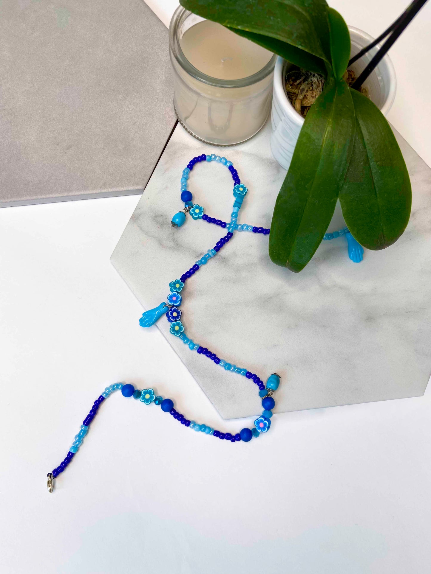 Handmade blue beaded belly chain made using light and dark blue beads, flower charms, turquoise stones, and hand charms.  