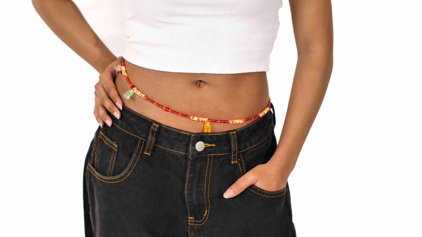 Handmade beaded belly chain made using orange glass beads, yellow and orange flat rubber beads, and gummy bear charms.