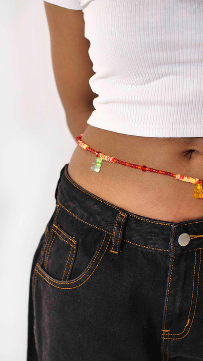 Handmade beaded belly chain made using orange glass beads, yellow and orange flat rubber beads, and gummy bear charms.