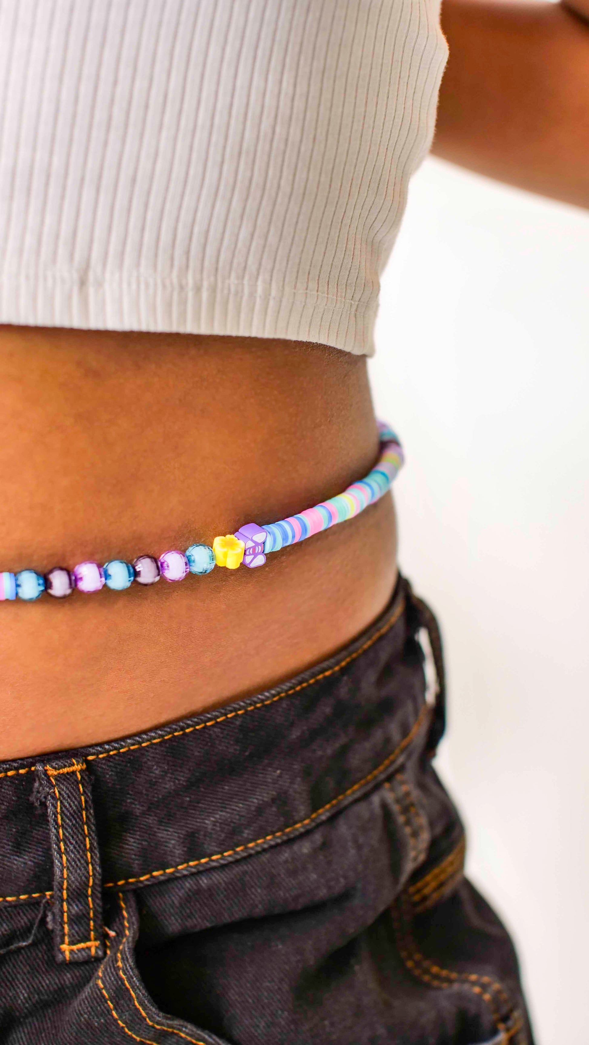 Handmade beaded belly chain made using multicolor flat rubber beads, flower and butterfly charms, and Discoball-like beads.