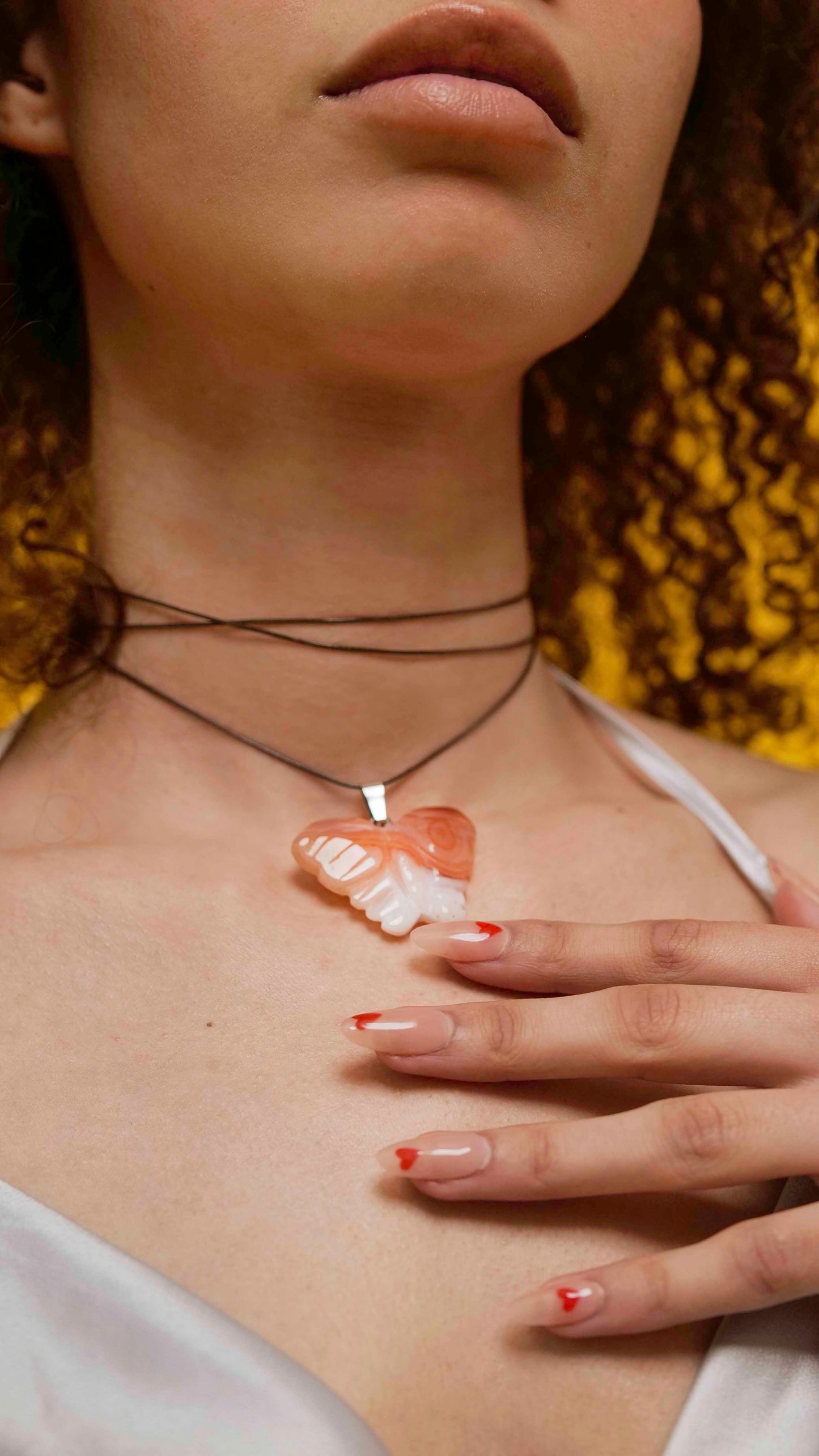 Handmade orange agate butterfly pendant necklace with a brown vegan leather string.