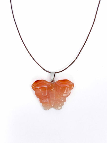 Handmade orange agate butterfly pendant necklace with a brown vegan leather string.