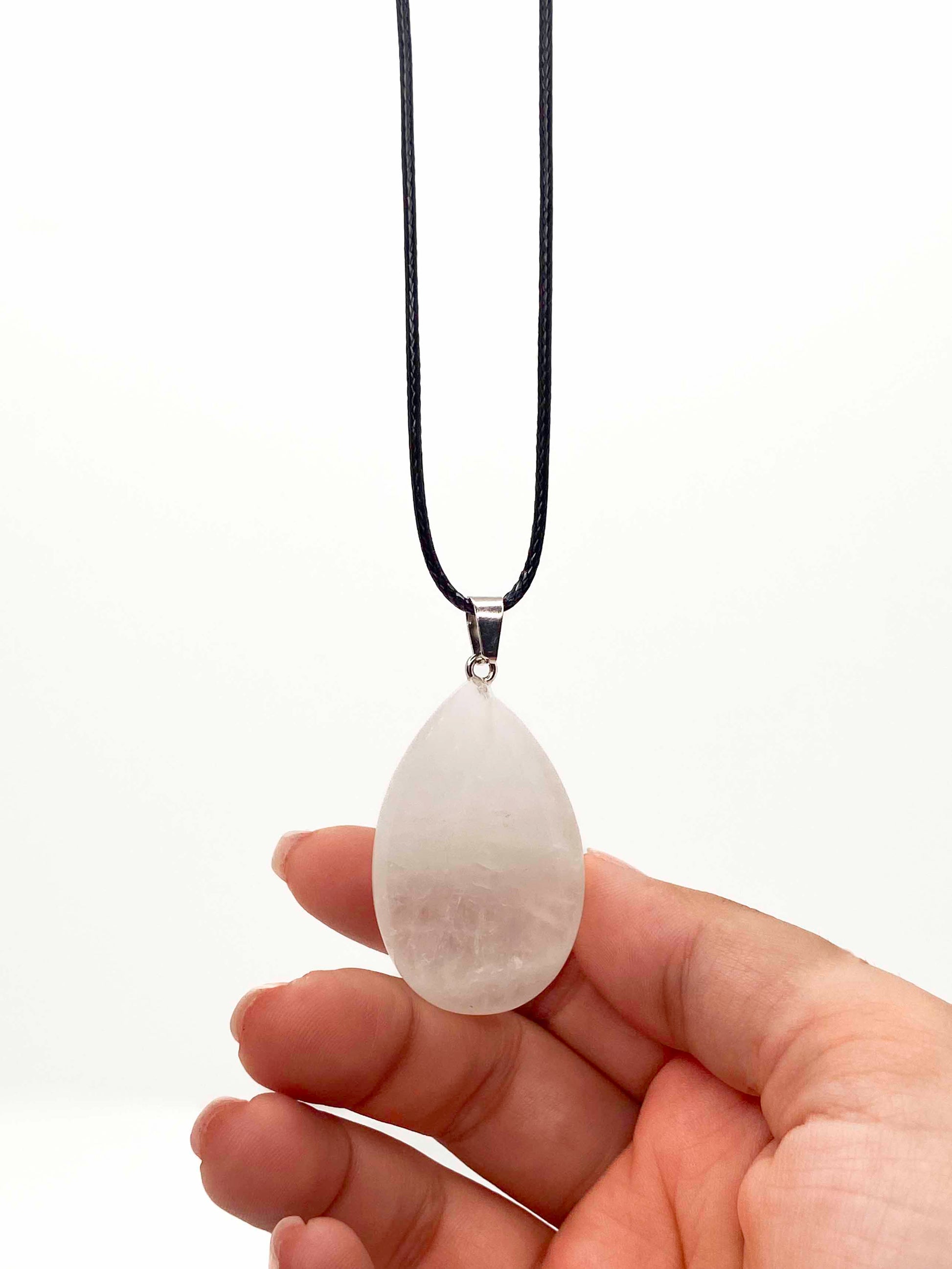 A handmade white jade teardrop pendant necklace with a black vegan leather string.